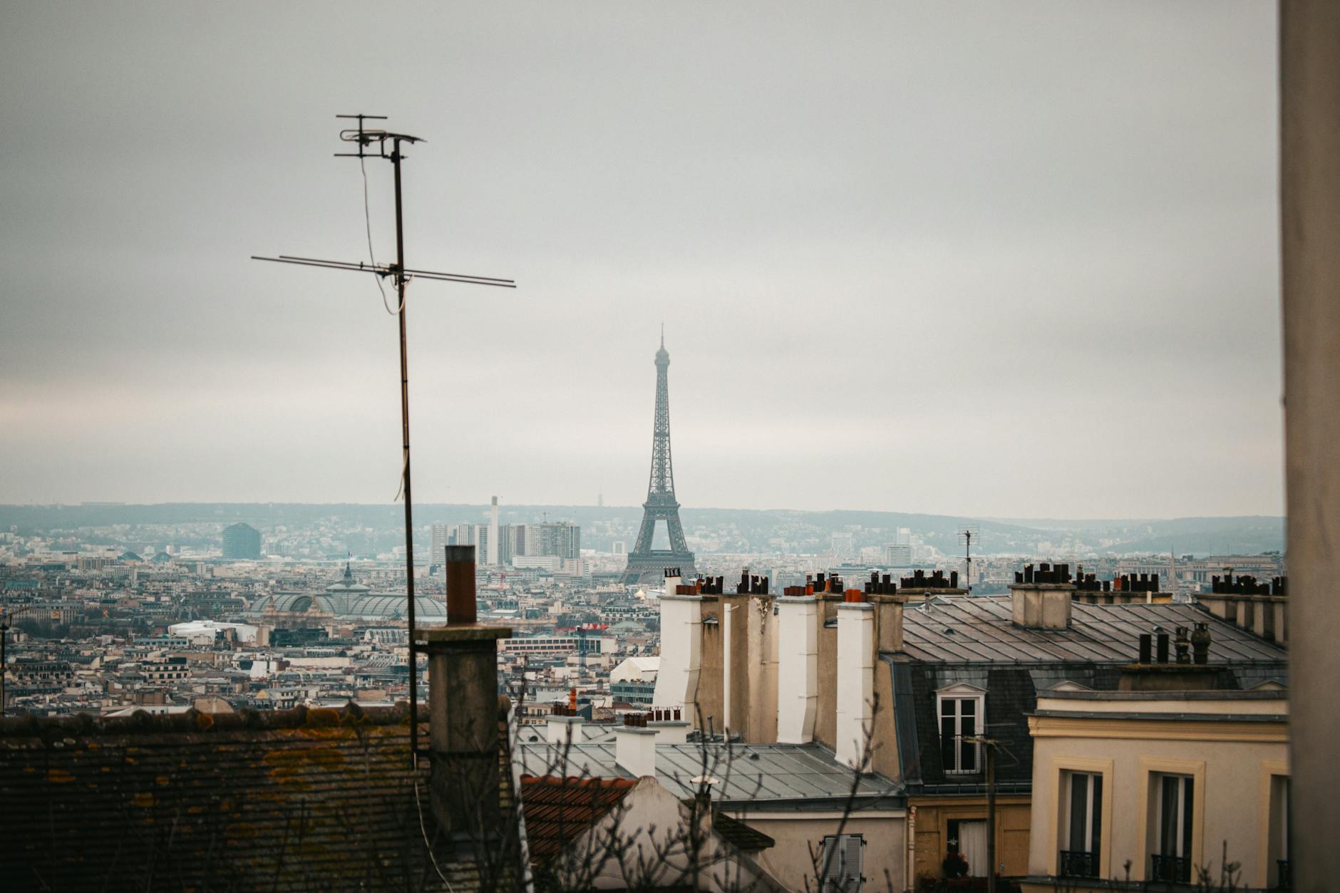 Close-up of a crossbody leather bag, silk scarf, and white sneakers packed for Paris