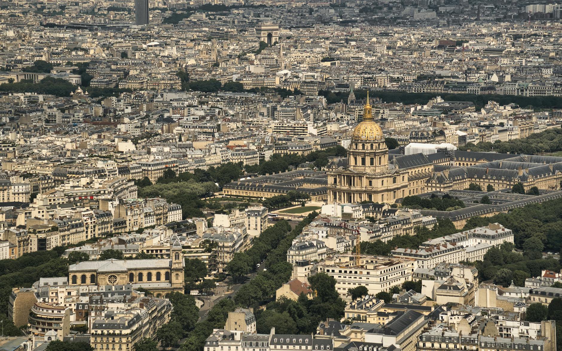 Woman in a trench coat and ballet flats walking along the Seine in spring